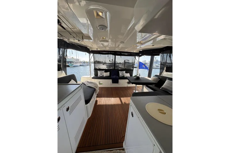 Slide: The Image of Interior view of 2020 Lagoon 46 catamaran with elegant seating and marina backdrop. - 7