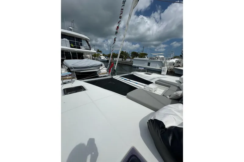 Slide: The Image of 2020 Lagoon 46 catamaran with spacious deck, docked under cloudy skies. - 75