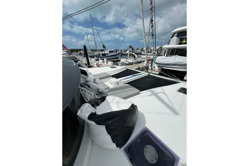 Slide: The Image of 2020 Lagoon 46 catamaran docked at a marina under a partly cloudy sky. - 76