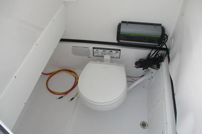Slide: The Image of 2026 Sportsman Open 252 Center Console boat interior with toilet and wiring. - 23