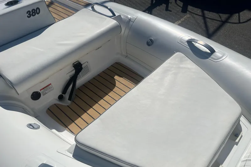 Slide: The Image of 2021 AB Inflatables ABJET 380 boat interior with cushioned seating and teak flooring. - 5