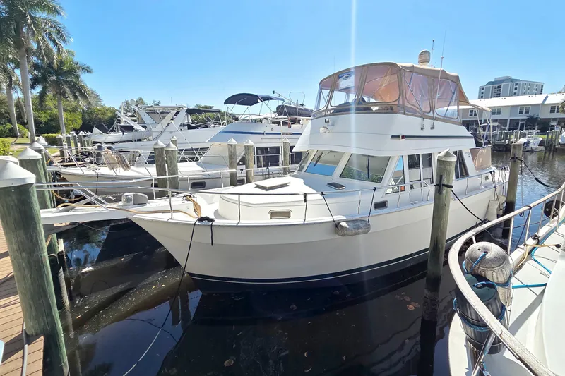 The Image of 2002 Mainship 430 Trawler docked at marina under clear blue sky. - 0