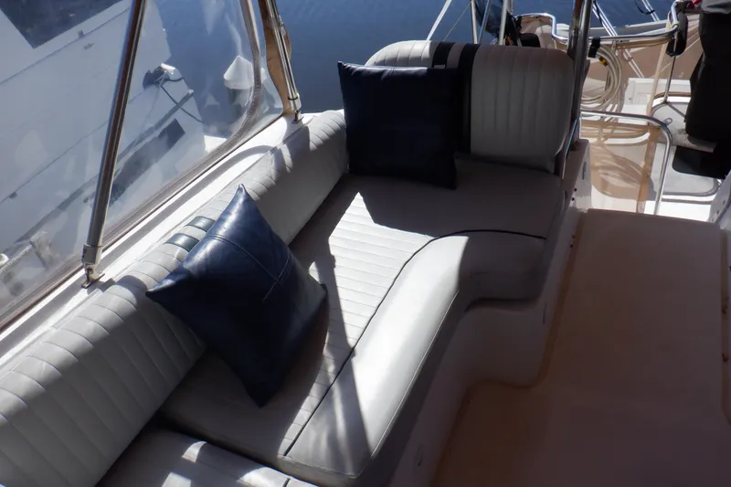 Slide: The Image of 2002 Mainship 430 Trawler interior with cushioned seating and blue pillows. - 22