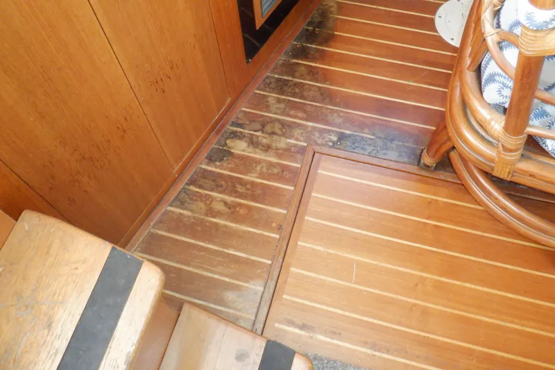 Slide: The Image of Wooden interior flooring of 2002 Mainship 430 Trawler, showing wear and discoloration. - 34