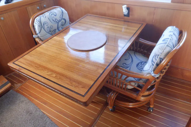 Slide: The Image of Elegant wooden dining area on 2002 Mainship 430 Trawler with cushioned chairs. - 35