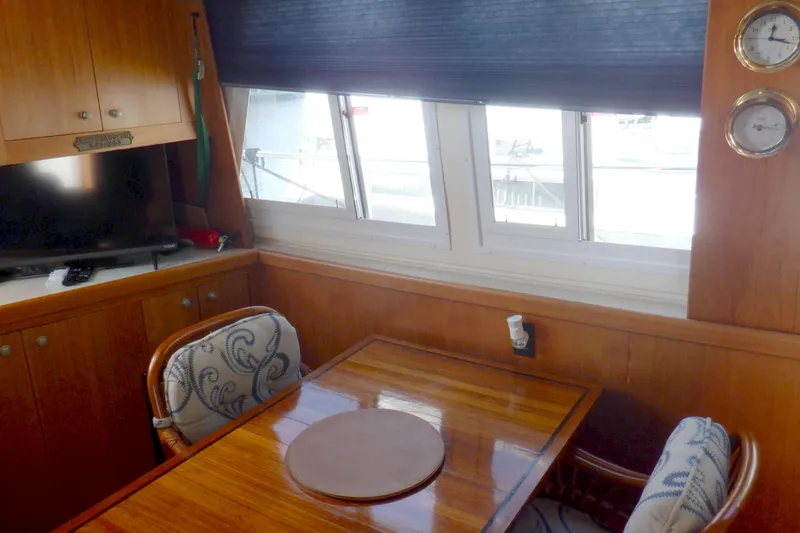 Slide: The Image of Interior of 2002 Mainship 430 Trawler with dining area and wooden cabinetry. - 36