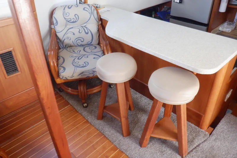 Slide: The Image of Interior of 2002 Mainship 430 Trawler with bar stools and patterned chair. - 38