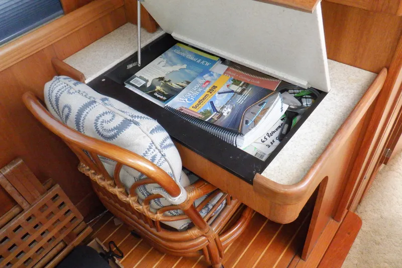 Slide: The Image of Cozy Mainship 430 Trawler interior with nautical guides and cushioned chair, 2002 model. - 43
