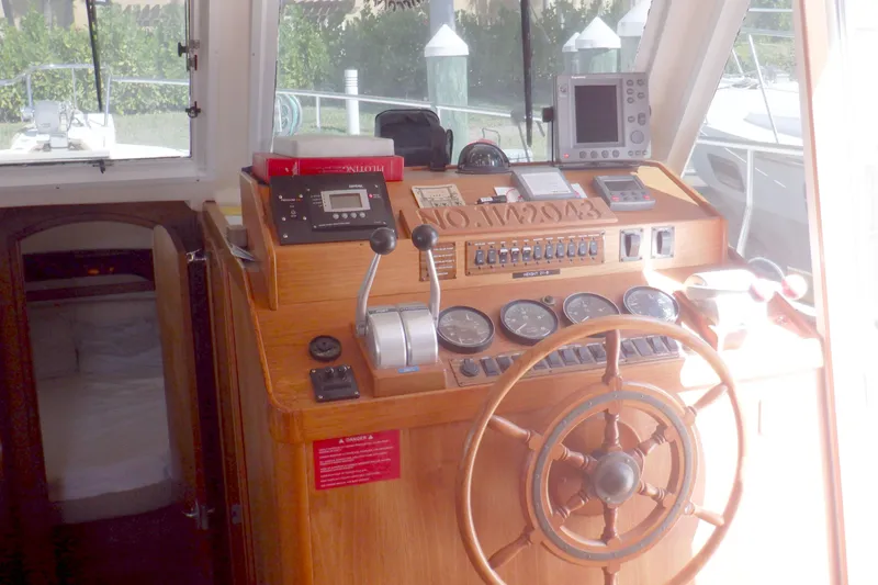 Slide: The Image of 2002 Mainship 430 Trawler helm with wooden steering wheel and navigation instruments. - 46