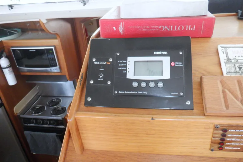 Slide: The Image of Control panel and kitchen area inside a 2002 Mainship 430 Trawler boat. - 47