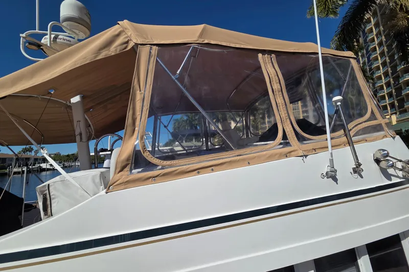 Slide: The Image of 2002 Mainship 430 Trawler with tan canopy, docked under clear blue sky. - 5