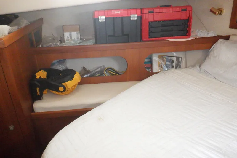 Slide: The Image of Cozy cabin interior of 2002 Mainship 430 Trawler with tools and fan on shelf. - 54