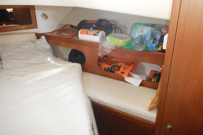 Slide: The Image of Cozy cabin interior of 2002 Mainship 430 Trawler with bed and storage shelves. - 56