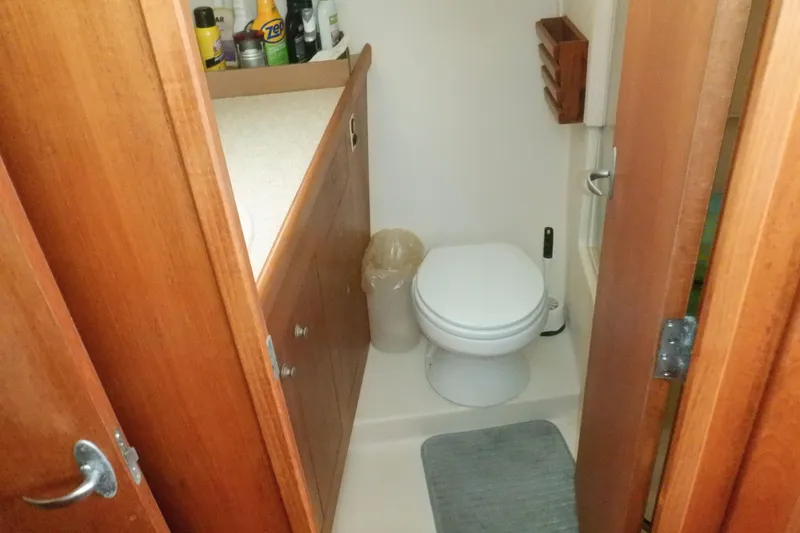 Slide: The Image of Bathroom interior of 2002 Mainship 430 Trawler with wooden cabinetry and toilet. - 58