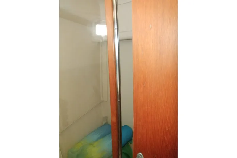 Slide: The Image of Interior view of 2002 Mainship 430 Trawler cabin with wooden door and colorful bedding. - 59