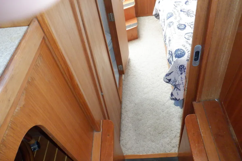 Slide: The Image of Interior hallway of 2002 Mainship 430 Trawler with wood paneling and carpeted floor. - 62