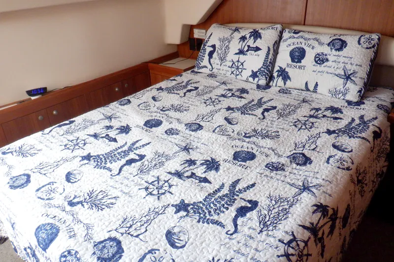 Slide: The Image of Cozy bedroom in 2002 Mainship 430 Trawler with nautical-themed bedding and wooden cabinetry. - 63