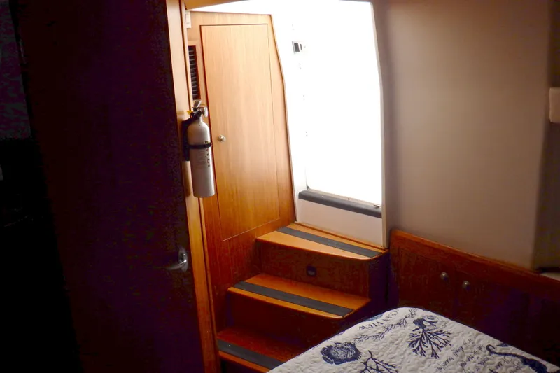 Slide: The Image of Interior of 2002 Mainship 430 Trawler with wooden stairs and fire extinguisher. - 65