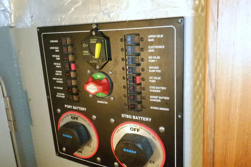 Slide: The Image of Control panel of a 2002 Mainship 430 Trawler, featuring battery and generator switches. - 70