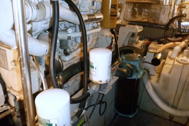 Slide: The Image of Engine room of a 2002 Mainship 430 Trawler with visible filters and components. - 73
