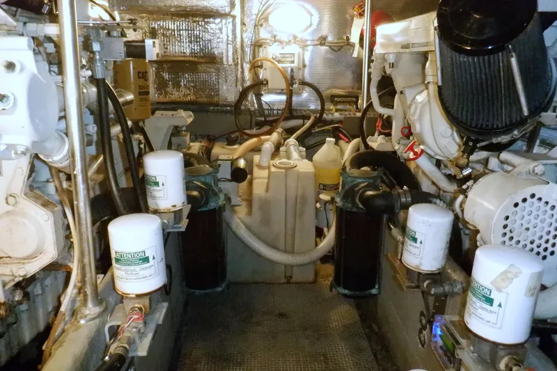Slide: The Image of Engine room of a 2002 Mainship 430 Trawler with visible filters and machinery. - 74