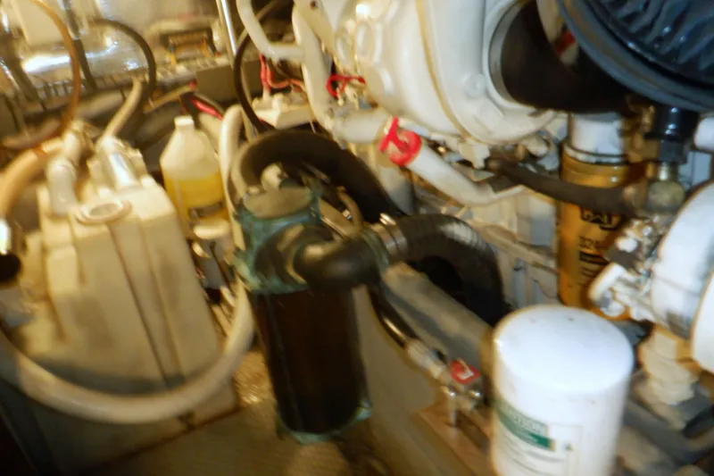 Slide: The Image of Engine room of 2002 Mainship 430 Trawler with visible hoses and components. - 75