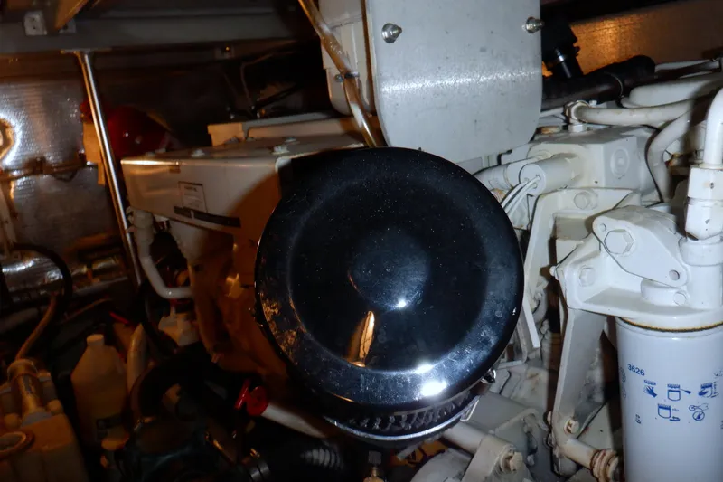 Slide: The Image of Engine room of a 2002 Mainship 430 Trawler, showcasing mechanical components and filters. - 76