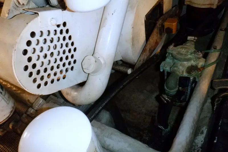 Slide: The Image of Engine compartment of a 2002 Mainship 430 Trawler, showcasing mechanical components. - 77