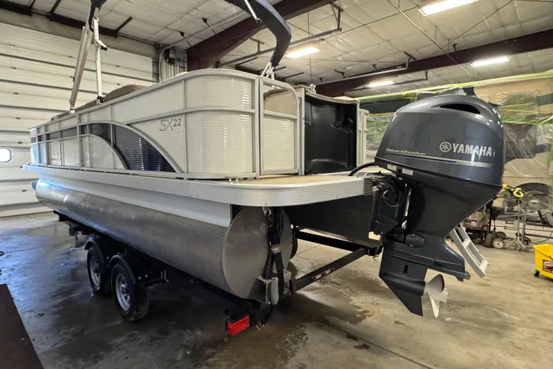 Slide: The Image of 2020 Bennington SX 22 SLX pontoon boat with Yamaha outboard motor in a garage. - 5