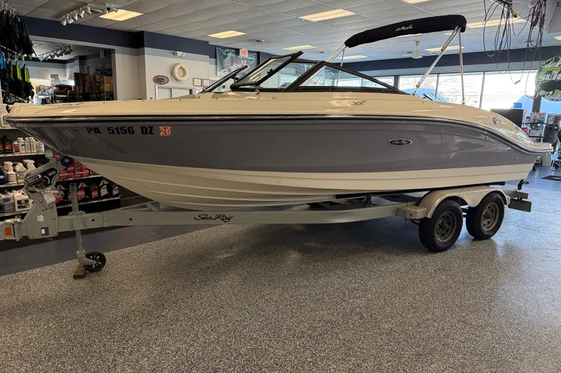 The Image of 2020 Sea Ray SPX 210 boat on trailer in showroom setting. - 1