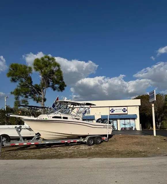 Slide: The Image of 2008 Grady-White Journey 258 boat on trailer outside store. - 5