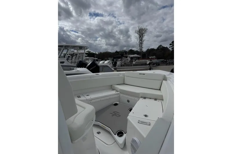 Slide: The Image of 2026 Sea Pro 245FLX Sandbar boat interior with seating, under a cloudy sky. - 2