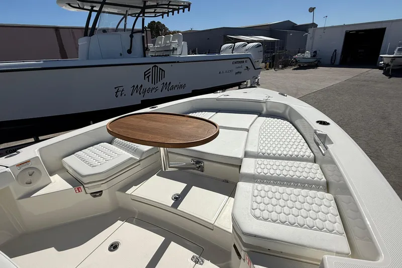 Slide: The Image of 2026 Pathfinder 2600 TRS boat with cushioned seating and wooden table at Ft. Myers Marine. - 17
