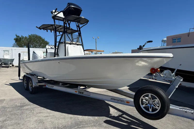 Slide: The Image of 2026 Pathfinder 2600 TRS boat on trailer, displayed outdoors under clear blue sky. - 2