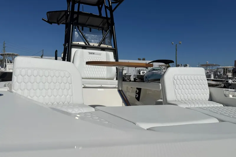Slide: The Image of 2026 Pathfinder 2600 TRS boat with white seating and sleek design under clear blue sky. - 20