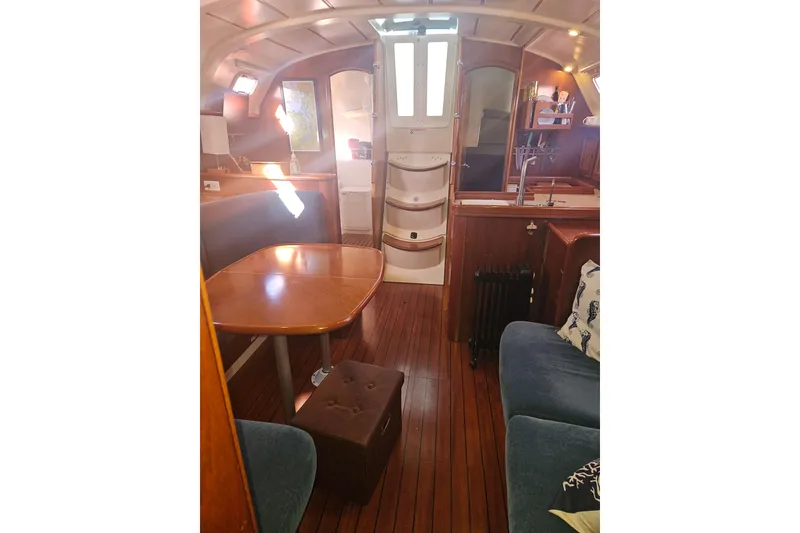 Slide: The Image of Interior of 1998 Beneteau 381 sailboat with wooden flooring and cozy seating area. - 19
