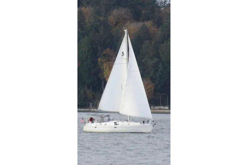 Slide: The Image of Sailing yacht Beneteau 381, 1998 model, cruising on a serene lake with forest backdrop. - 2