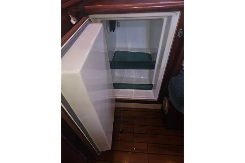 Slide: The Image of Open refrigerator inside a 1998 Beneteau 381 sailboat, showcasing interior shelves. - 27