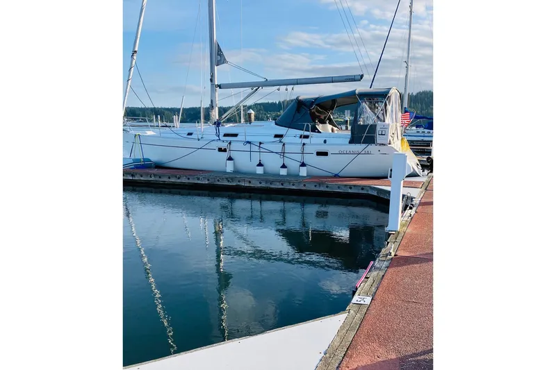 Slide: The Image of 1998 Beneteau 381 sailboat docked at marina, reflecting on calm water. - 3