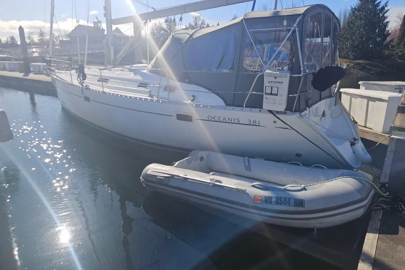 Slide: The Image of 1998 Beneteau Oceanis 381 sailboat docked with inflatable dinghy in sunny marina. - 4