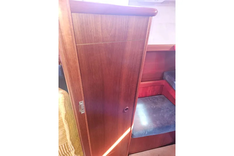 Slide: The Image of Interior of 1998 Beneteau 381 sailboat, featuring wooden cabinetry and seating area. - 41