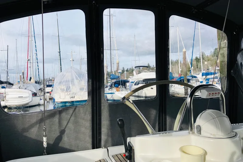 Slide: The Image of Interior view from a 1998 Beneteau 381 sailboat, overlooking a marina with docked boats. - 17