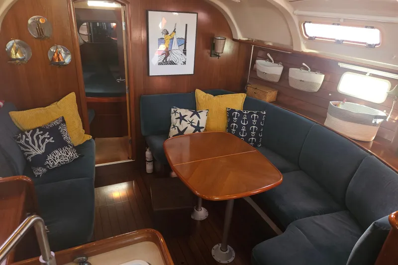 Slide: The Image of Cozy interior of 1998 Beneteau 381 sailboat with blue seating and wooden table. - 20