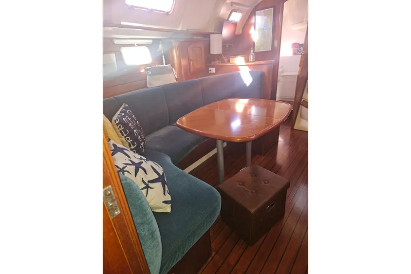 Slide: The Image of Interior of 1998 Beneteau 381 sailboat with wooden table and blue seating. - 21