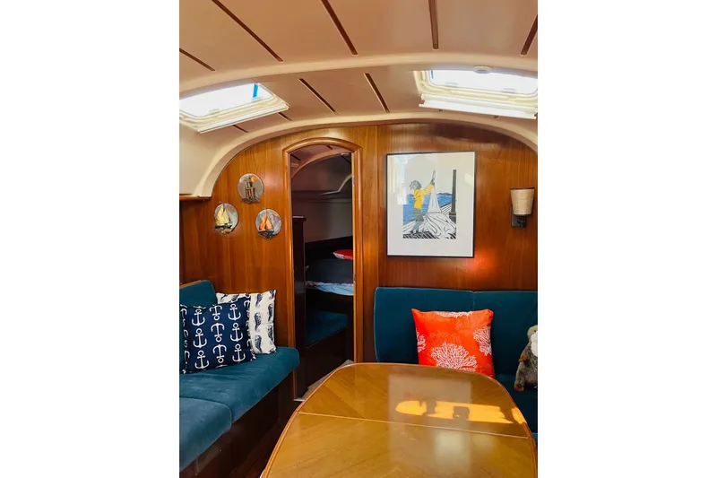 Slide: The Image of Interior of 1998 Beneteau 381 sailboat with wooden flooring and cozy seating area. - 23