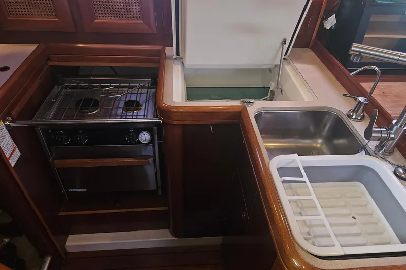 Slide: The Image of Galley kitchen in 1998 Beneteau 381 sailboat with stove, sink, and storage. - 26