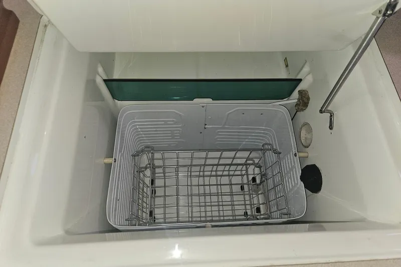 Slide: The Image of Open storage compartment in 1998 Beneteau 381 boat with wire basket. - 28