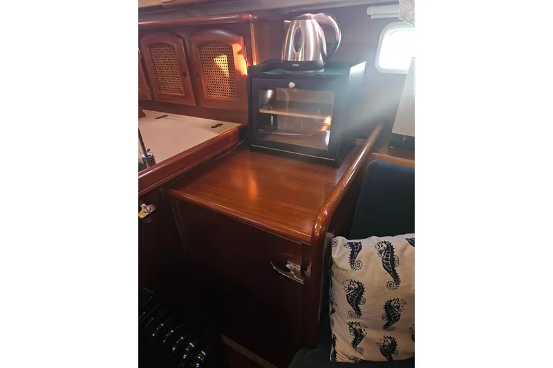 Slide: The Image of Interior of 1998 Beneteau Oceanis 381 yacht, featuring wooden cabinetry and seating area. - 30