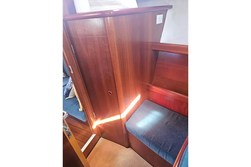 Slide: The Image of 1998 Beneteau Oceanis 381 interior navigation station with wooden finish and control panel. - 38