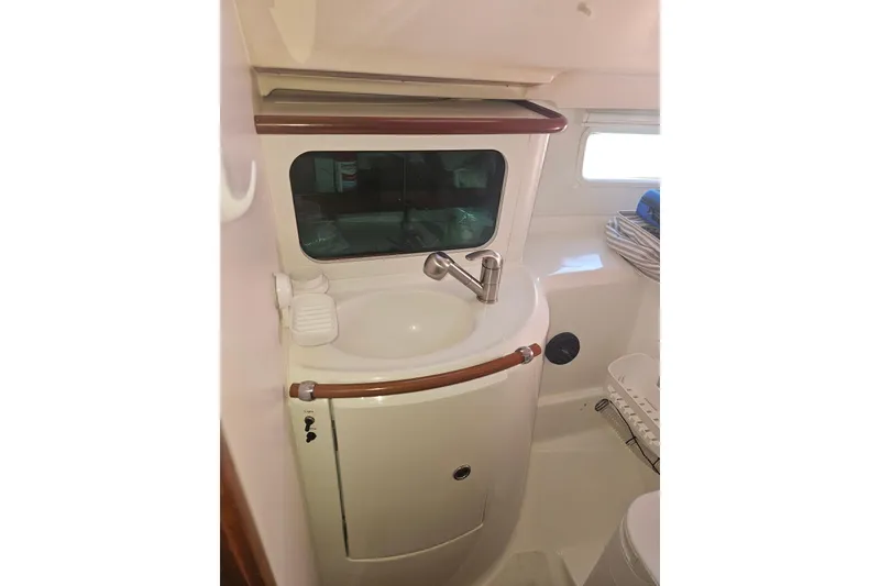 Slide: The Image of 1998 Beneteau 381 sailboat cockpit with cushioned seating and marina view. - 60